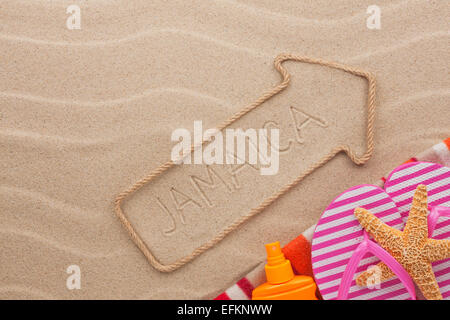 Jamaica  pointer and beach accessories lying on the sand, as background Stock Photo