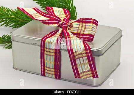 Festive tin gift box with wide ribbon bow. Stock Photo
