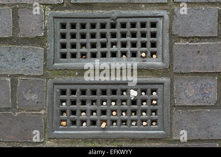 cigarette butts placed inside air brick Stock Photo