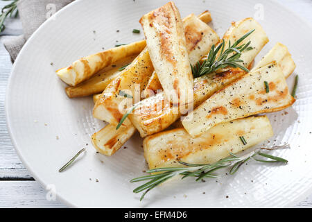 baked parsnips piece on plate, food closeup Stock Photo