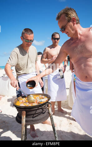 DOMINICAN REPUBLIC. Men taking part in a paella cook-off on Punta Cana beach. Stock Photo