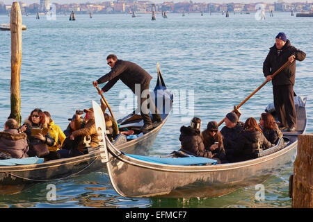 Two gondoliers rowing full gondolas on the lagoon Venice Veneto Italy Europe Stock Photo