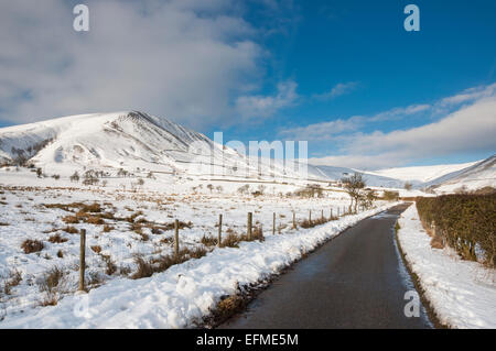 An English country lane in a snowy winter landscape in the Peak District, Derbyshire. Stock Photo