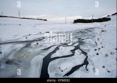 The River Spey in mid Winter frozen with only a trickle of water flow.  SCO 9542. Stock Photo