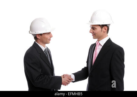 Two young Engineers closing a deal, isolated in background Stock Photo
