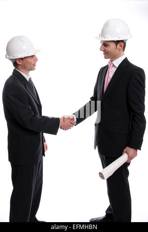Two Young Engineers closing a deal, isolated in background Stock Photo