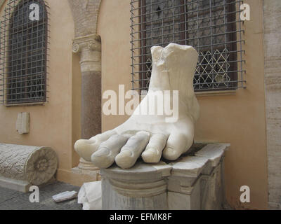 This huge foot was part of the Colossus of Constantine, a huge statue of the Roman Emperor Constantine that once stood in the Basilica of Maxentius, near the Roman Forum in Rome. The foot is carved from marble. The statue dates to after Constantine's great victory over Maxentius at the Battle of Milvian Bridge in A.D. 312. In Late Antiquity, the statue was pillaged for its parts. This foot, hands, and head are now housed in the Capitoline Museum in Rome. The photo dates to March 2014. Stock Photo