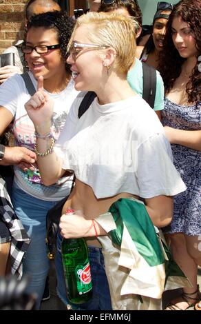 Miley Cyrus shows off her toned midriff as she leaves her Tribeca hotel in New York City. Cyrus' dog is spotted behind her as she stops and meets fans.  Featuring: Miley Cyrus Where: New York City, New York, United States When: 05 Aug 2014 Stock Photo