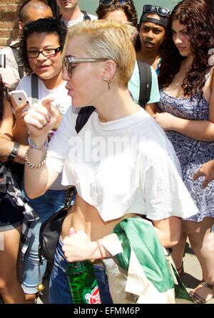 Miley Cyrus shows off her toned midriff as she leaves her Tribeca hotel in New York City. Cyrus' dog is spotted behind her as she stops and meets fans.  Featuring: Miley Cyrus Where: New York City, New York, United States When: 05 Aug 2014 Stock Photo