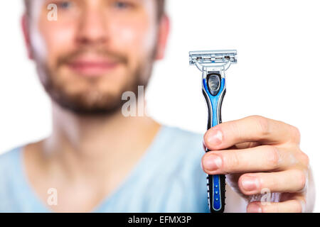 Young man guy with beard showing disposable blue razor blade, studio shot on white background. Cropped image Stock Photo