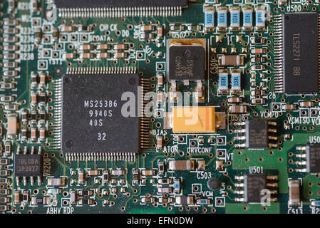 Computer Circuit Boards Close-up | WASHINGTON — A microprocessor labeled "MS253B6" anchors this macro view of a computer circuit board, surrounded by resistors, capacitors, and voltage regulators soldered to the green substrate. Component labels such as "DRVCONF" and "VCMPO" indicate circuitry associated with disk-drive voice-coil motor control. Boards of this design typically govern precision mechanical functions within data storage hardware. Stock Photo