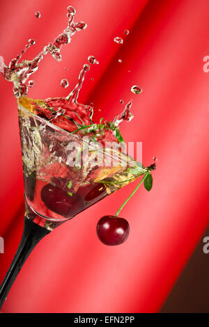 view of  martini glass with vermouth and cherry dropping in Stock Photo