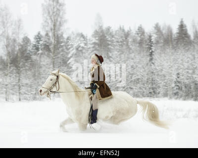 Attractive woman riding a white horse, winter landscape Stock Photo