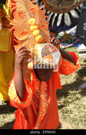 A young masquerader adjusts teh headdress of his costume during a Carnival competition in Port of Spain, Trinidad. Stock Photo