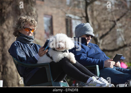 The London Borough of Richmond upon Thames in south-west London, England, UK 8th Feb, 2015.  People sit along the Thames River pathway enjoying the sunny winter weather as temperatures reach 10 degrees in Richmond, Outer London, UK Credit:  Jeff Gilbert/Alamy Live News Stock Photo