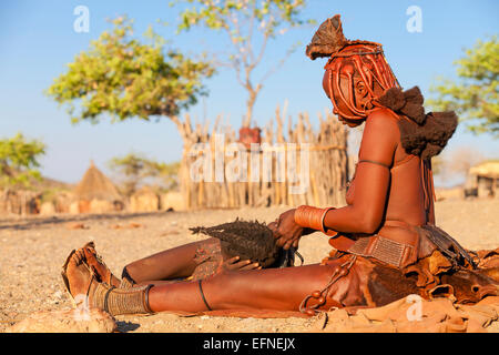 A Himba woman making traditional braids on a young girl, Namibia. Stock Photo
