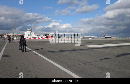 Gibraltar rock. Cars and pedestrians cross the runway of Gibraltar airport at the border of Spain and Gibraltar. overseas territory Gibraltar. Stock Photo