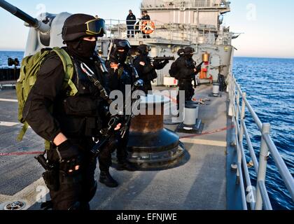 Portuguese Navy commandos in black uniforms prepare for visit, board, search and seizure operation team check weapons part of NATO exercise Noble Justification aboard the USS Leyte Gulf October 17, 2014 in the Alboran Sea. Stock Photo