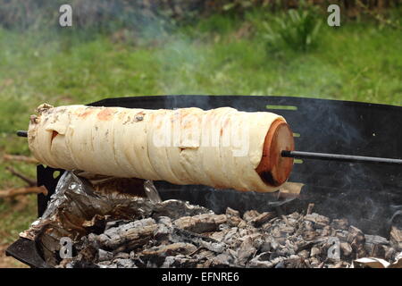 outdoor cooking kurtos kalacs on camp fire, traditional transylvanian cake Stock Photo