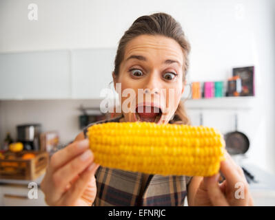 Funny portrait of young woman eating boiled corn Stock Photo