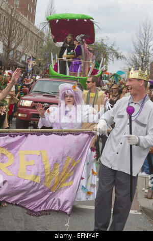 People in colorful costumes and the King and Queen of Misrule on a float romp in the Spring Mardi Gras parade in Asheville, NC Stock Photo