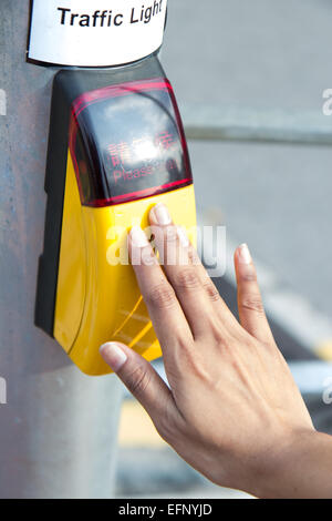 hand presses the button on the pedestrian crossing Stock Photo