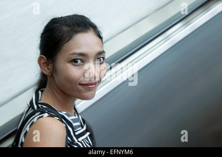 woman riding on escalators Stock Photo