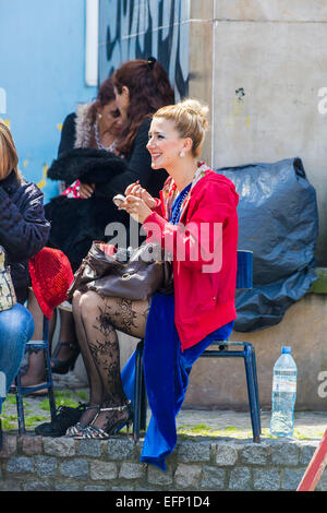 Pretty young blonde woman performer, a tango dancer, laughing as she applies her make up in La Boca, Buenos Aires, Argentina Stock Photo