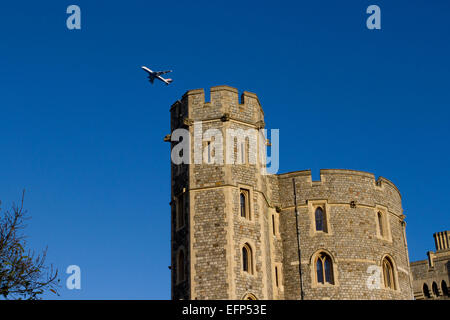 King Edward III Tower at Windsor Castle, Berkshire, England with airplane flying overhead in January Stock Photo