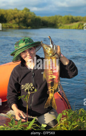 Woman with salmon fish in her hands, Kamchatka Peninsula, Russia Stock Photo