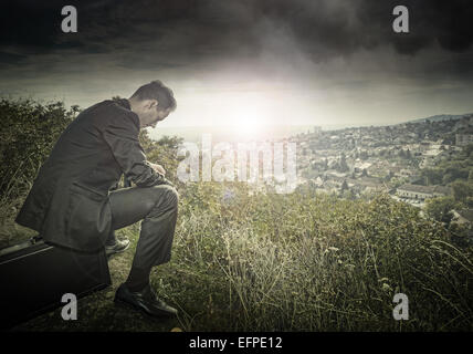 Sad, lonely businessman on the hillside Stock Photo