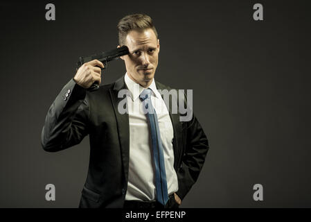 exasperated business man holding a gun to his head Stock Photo