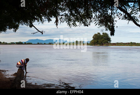 Woman collecting water in the Omo river ( Ethiopia) Stock Photo