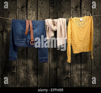 Women's clothing on a clothesline on wood background Stock Photo