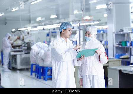 Workers having discussion in ecigarette factory Stock Photo