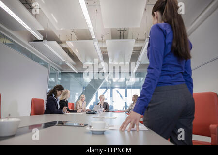 Woman in office with colleagues in background Stock Photo