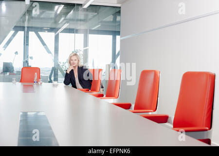 Woman sitting on orange chair in conference room Stock Photo