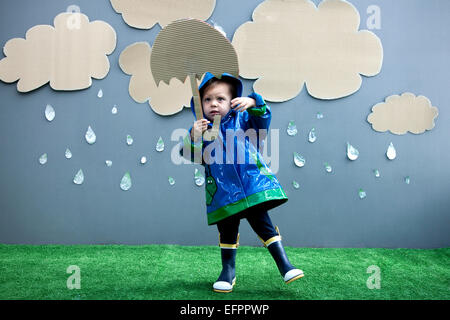 Baby girl with rain and umbrella cutouts Stock Photo