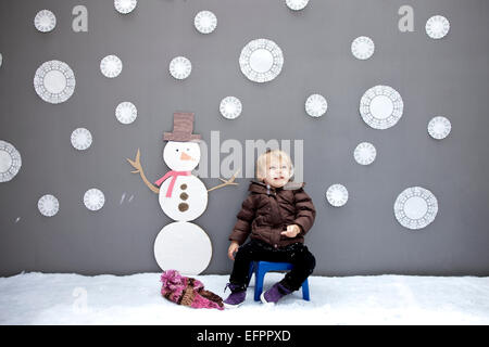 Baby girl with snowflake and snowman cutouts Stock Photo