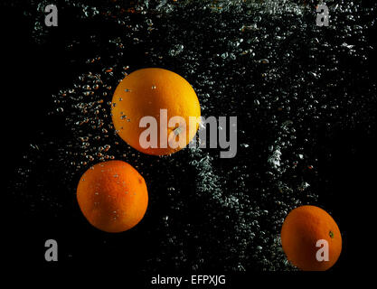 Oranges water with air bubbles. Photo on black background. Stock Photo