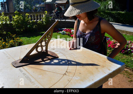 Tourist girl with hat looking sun watch in a park. Stock Photo