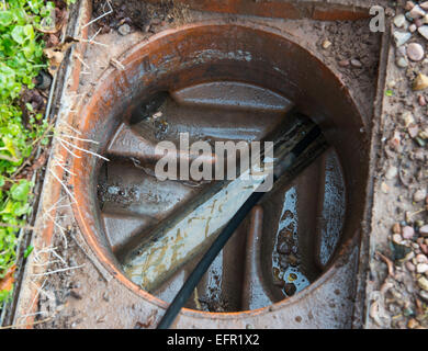 Clearing a blocked house drain with drain rods Stock Photo - Alamy