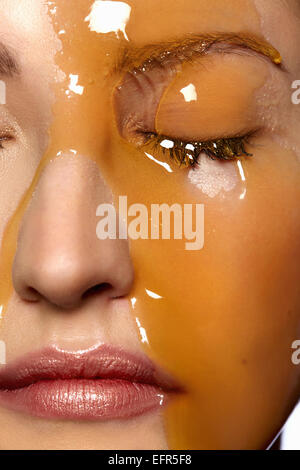 Female model's face covered in honey Stock Photo