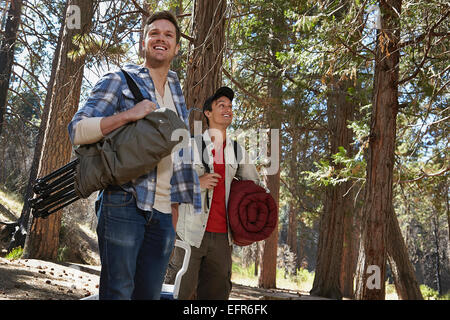 Two young men walking in forest with camping equipment, Los Angeles, California, USA Stock Photo