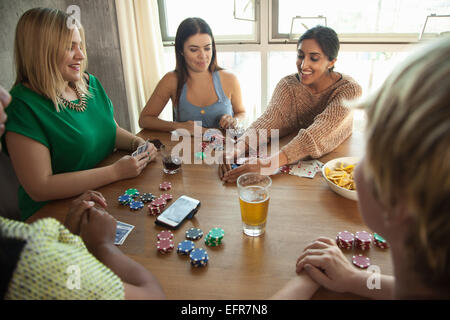 Group of friends playing cards around table Stock Photo