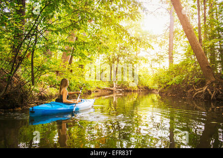 Young woman kayaking on forest river, Cary, North Carolina, USA Stock Photo