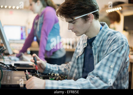 Two people in a computer repair shop. Technicians, young people working to repair computers. Stock Photo