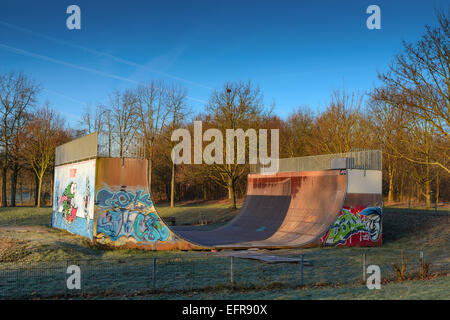 Stock image of a skateboard ramp in a park covered in graffiti Stock Photo