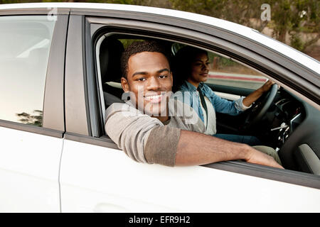 Portrait of young man looking out of of car window Stock Photo