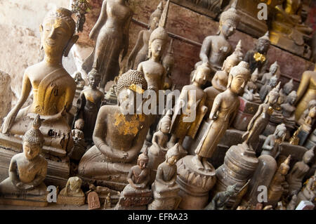 Horizontal close up of hundreds of Buddha statues in Pak Ou or Tam Ting caves on a sunny day. Stock Photo